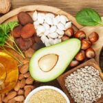 Foods rich in vitamin E including wheat germ oil, dried wheat germ, dried apricots, hazelnuts, almonds, parsley leaves, avocado, walnuts, pumpkin seeds, sunflower seeds, spinach and bell pepper