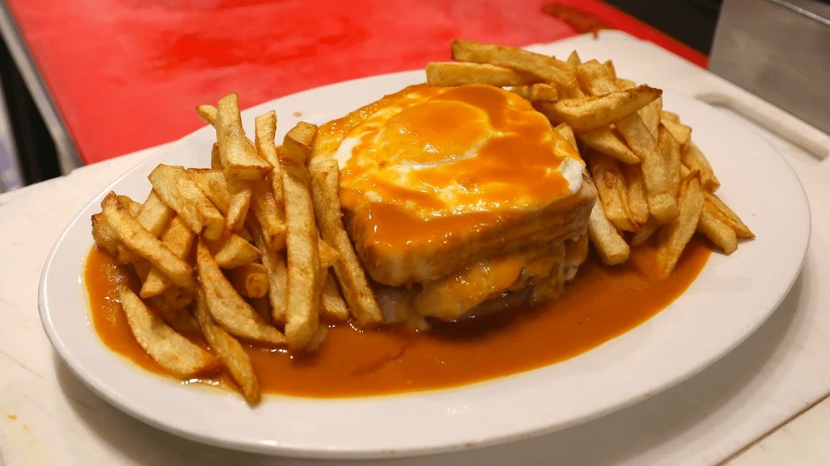 Francesinha, a hearty Portuguese sandwich layered with meats, cheese, and a rich tomato beer sauce, a signature food in Portugal