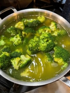 Fresh broccoli florets being prepared for a homemade dog food recipe, highlighting the natural green color and healthy texture of the vegetable.