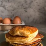 Frying pan cottage cheese pancakes with golden brown edges, showcasing a fluffy and appetizing texture, ideal for a quick breakfast using a food blender.