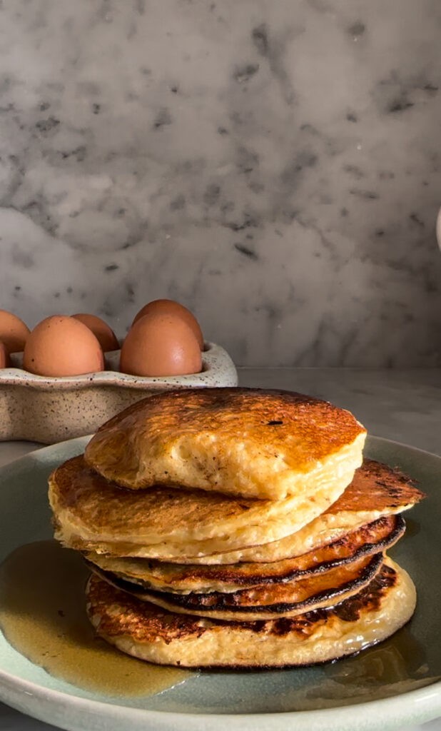 Frying pan cottage cheese pancakes with golden brown edges, showcasing a fluffy and appetizing texture, ideal for a quick breakfast using a food blender.