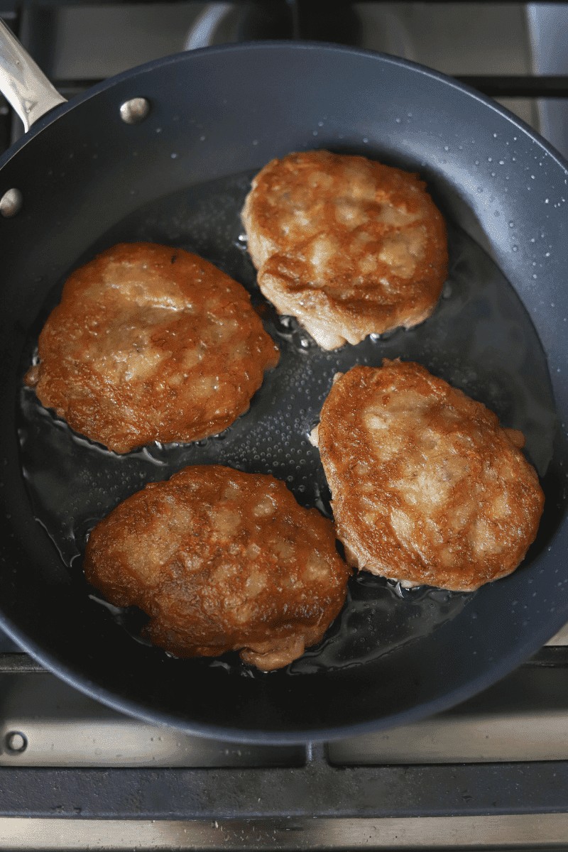 Golden brown brinhola, Cape Verde food banana fritters, frying in a skillet