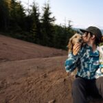 Happy cat owner giving Earthborn Holistic cat treats to their feline friend. Earthborn cat food promotes healthy bonding with pets through nutritious and delicious meals.