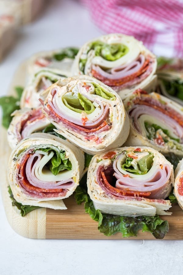 Italian pinwheel appetizers arranged on a wooden cutting board, showcasing their colorful layers and inviting presentation.