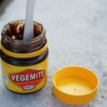 Jar of Vegemite, a popular Australian food spread, on toast with butter