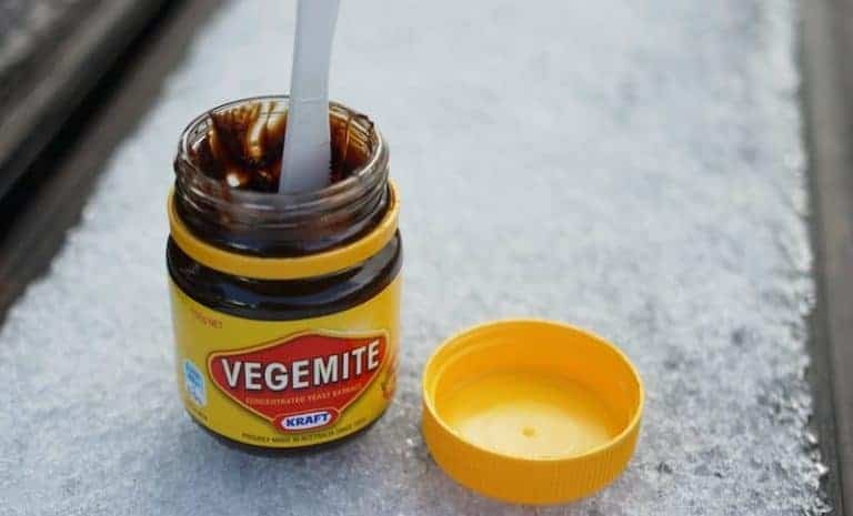 Jar of Vegemite, a popular Australian food spread, on toast with butter