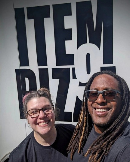 Jonathan Traylor and his wife Kellie, founders of Item9 Pizza, standing proudly in front of their pizza food truck, ready to serve the Raleigh community.