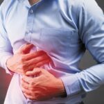 Man holding stomach in pain, experiencing diarrhea from food triggers