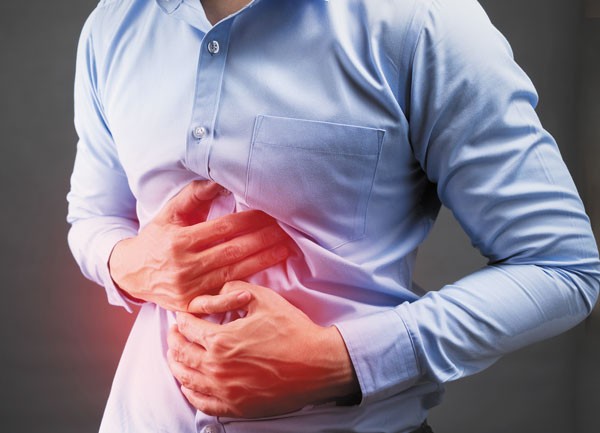 Man holding stomach in pain, experiencing diarrhea from food triggers