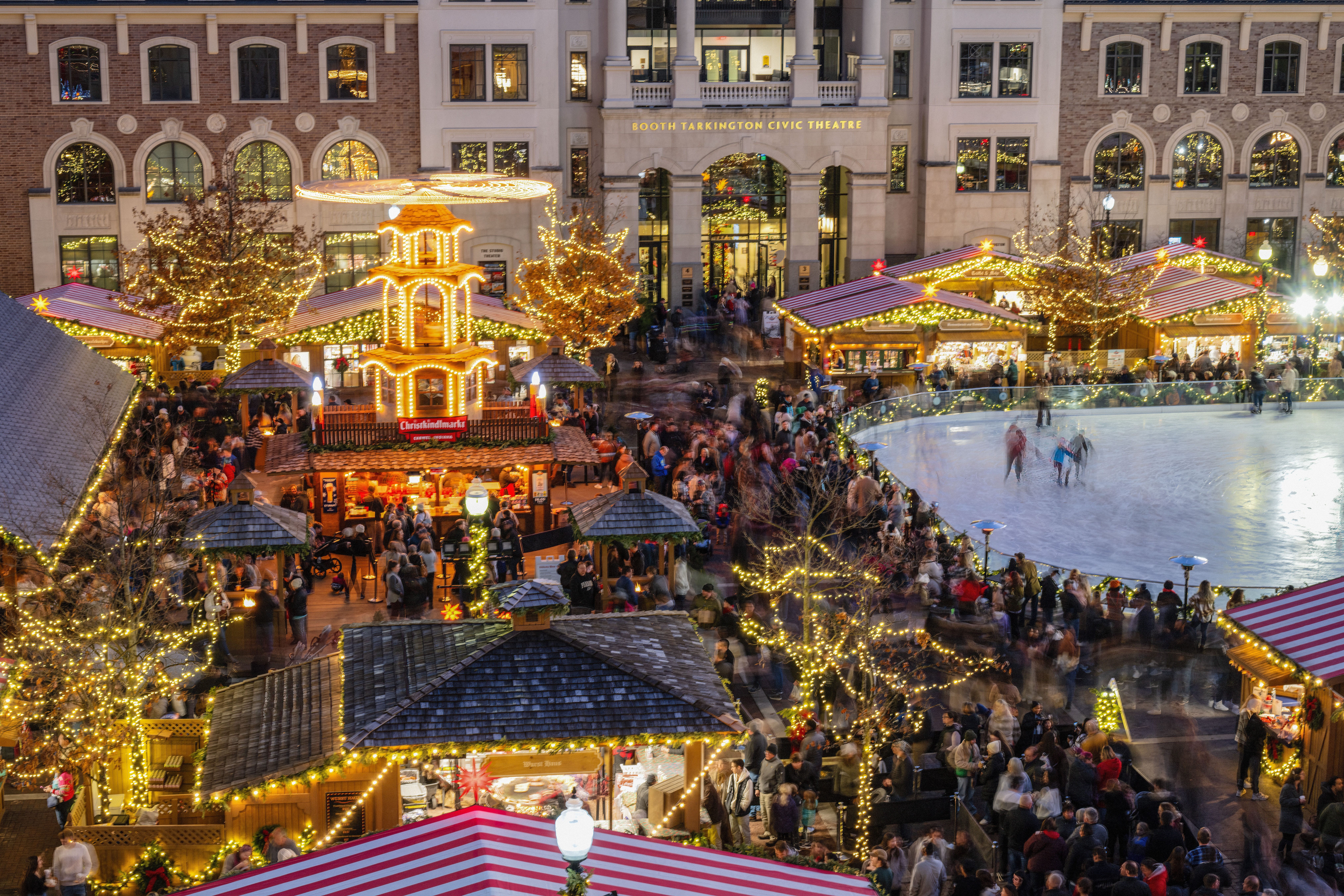 People enjoying food at an outdoor Christmas market, symbolizing holiday dining needs when searching for 'fast food restaurants near me open now'.