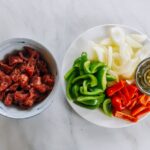 Preparing marinated beef, bell peppers, and onions for pepper steak