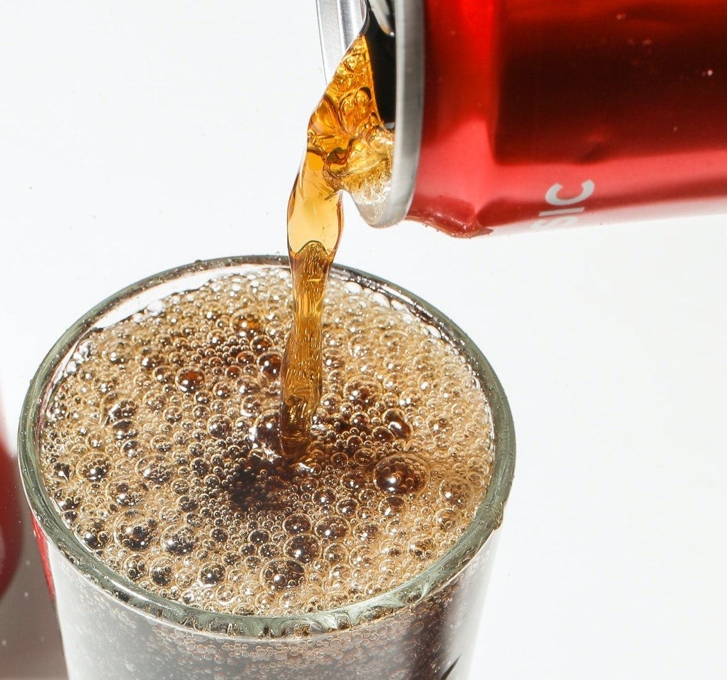 Soda poured into a glass with ice