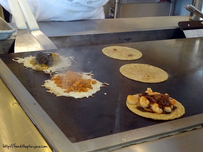 Tacos being grilled with cheese at Puesto Mexican Street Food in La Jolla