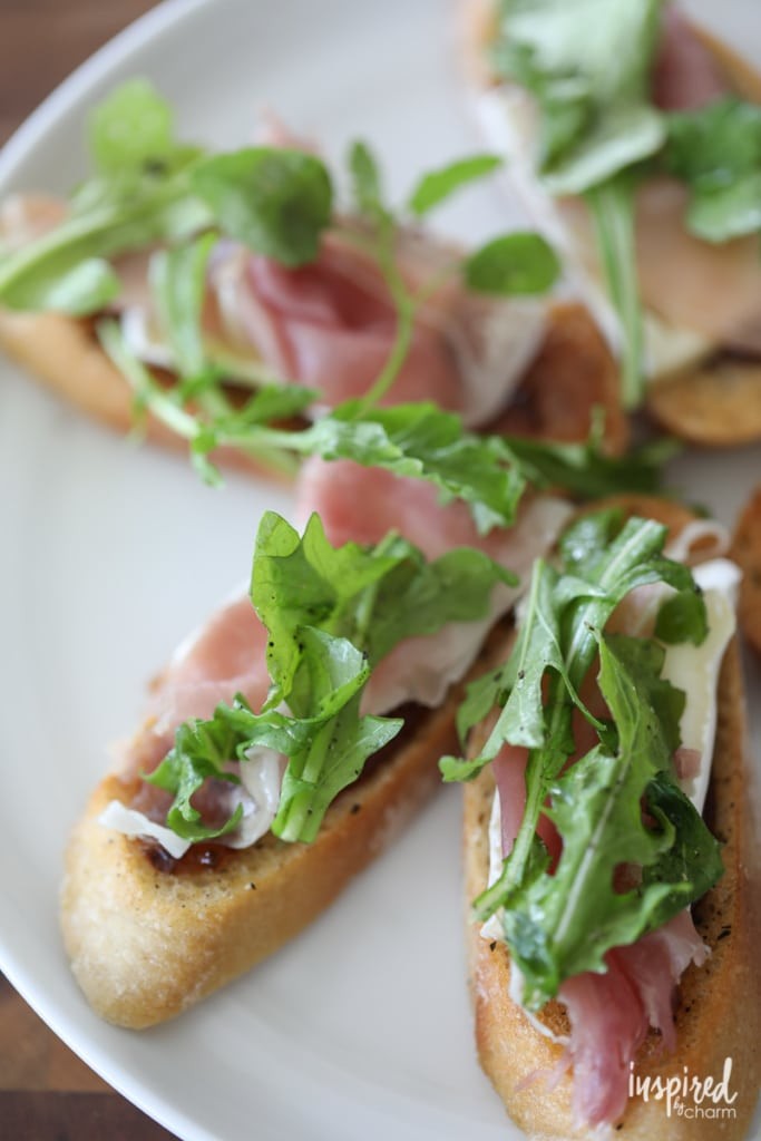 This Brie, Fig, and Prosciutto Crostini recipe makes a flavorful and easy appetizer. #appetizer #crostini #fig #arugula #brie #prosciutto