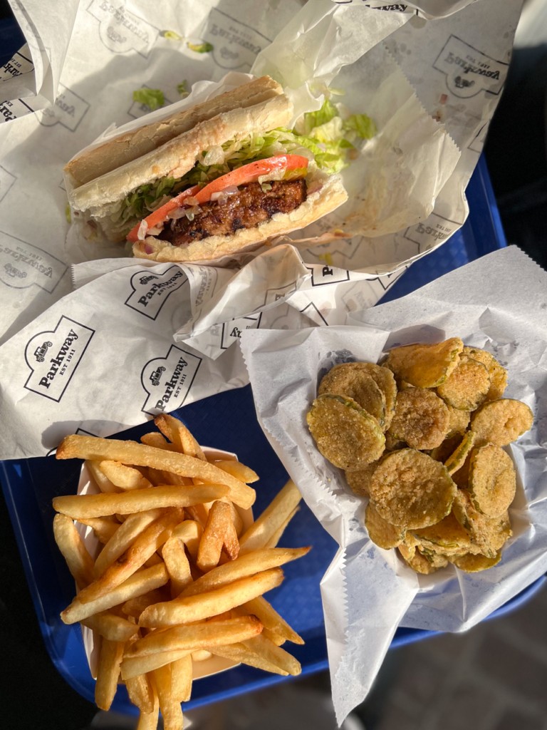 Vegan po'boy sandwich with fried pickles and fries