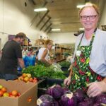 Volunteer at a food pantry organizing fresh produce like cabbage, highlighting the availability of healthy groceries at food pantries.