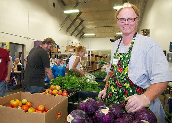 Volunteer at a food pantry organizing fresh produce like cabbage, highlighting the availability of healthy groceries at food pantries.