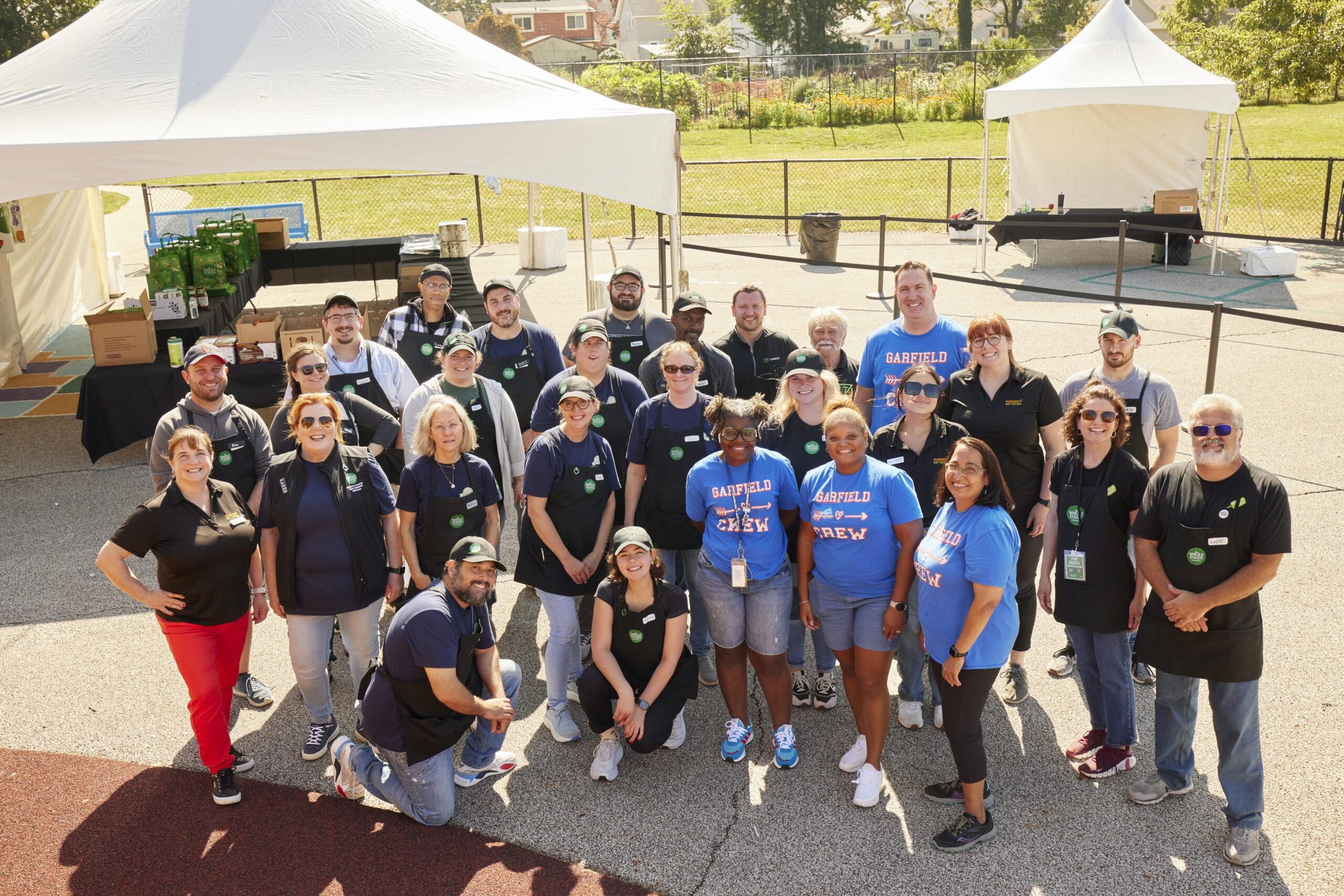 Whole Food Market store community support in action, volunteers distributing healthy food.