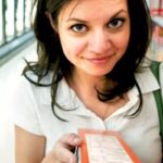 Woman carefully reading ingredient list on food packaging, highlighting allergen awareness for safe food choices