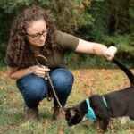 woman with cat outside on a harness and leash