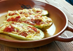 Zucchini halves filled with vegetables and cheese, baked and golden brown, showcasing a family-friendly whole food meal.