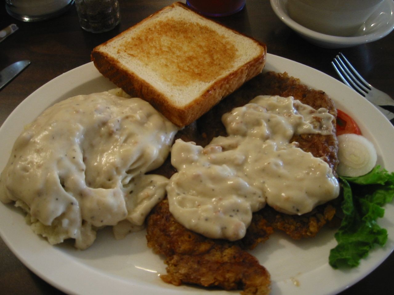 Chicken fried steak served with creamy gravy, showcasing its crispy, golden-brown breading.