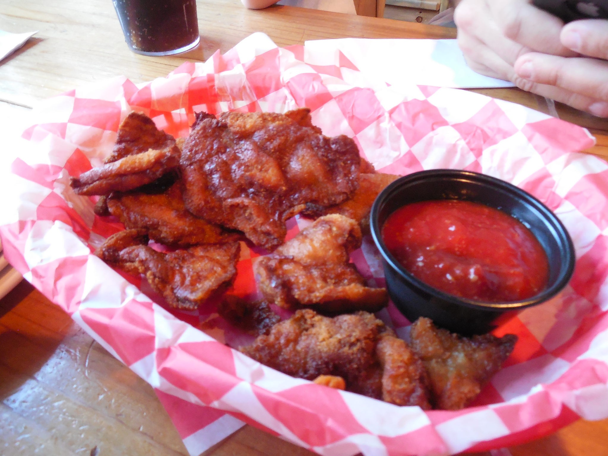 A plate of golden-brown Rocky Mountain Oysters served with a side of dipping sauce.