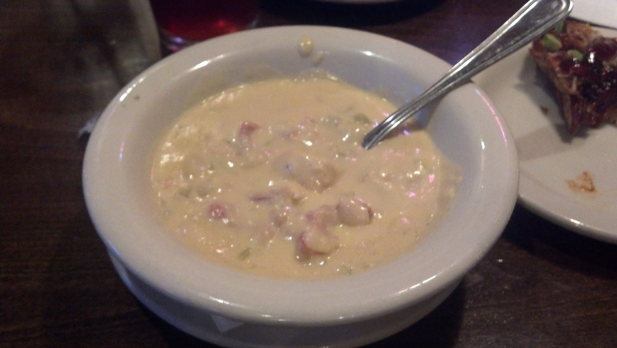 A bowl of white chicken chili topped with cheese, sour cream, and cilantro