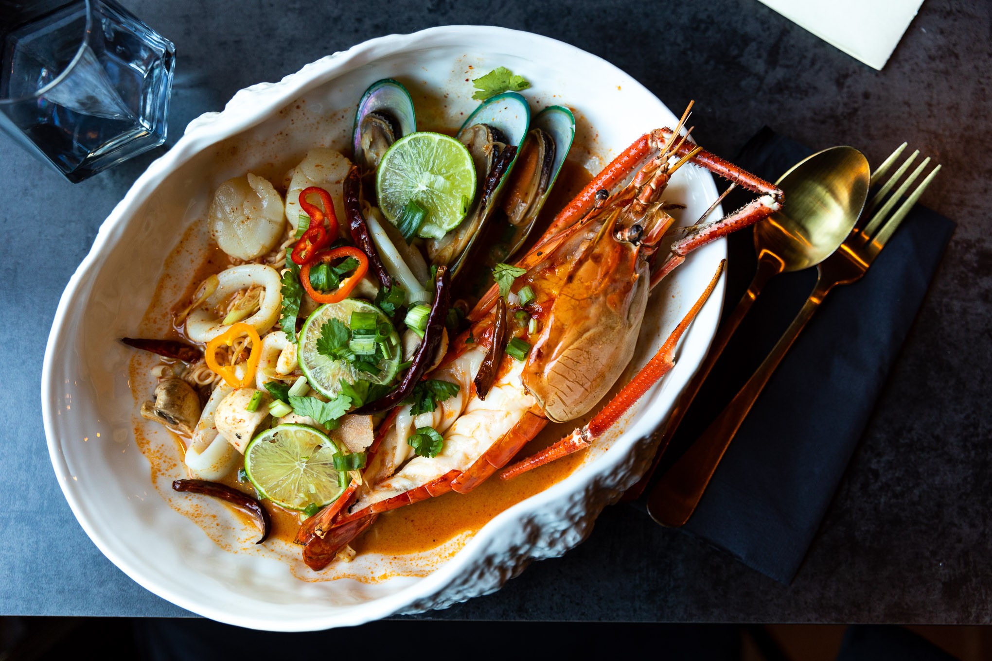 A colorful plate of seafood, limes, and chili pepper at Thai Food Near Me.