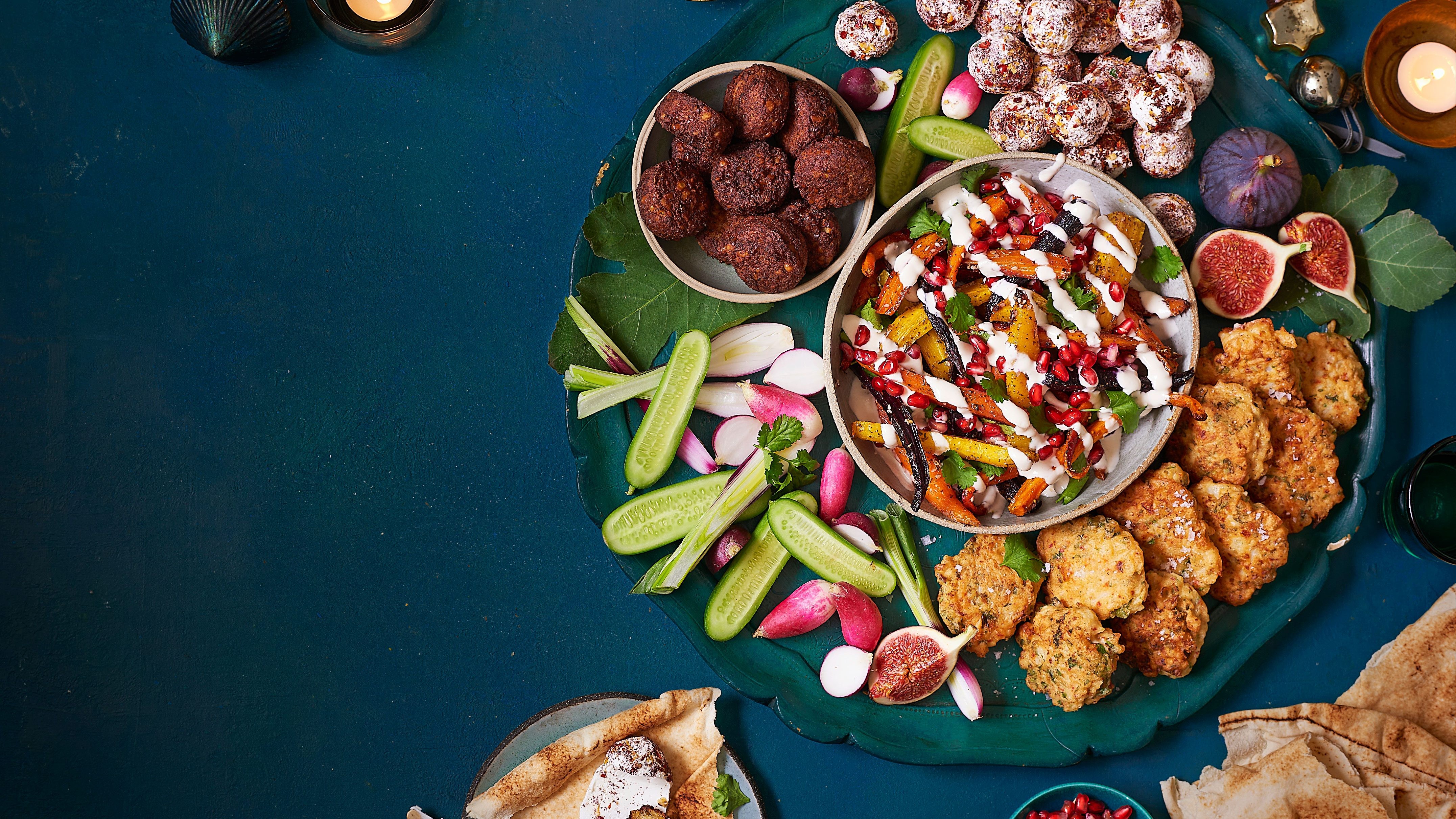 Meze style sharing board featuring falafel, cucumber and radish