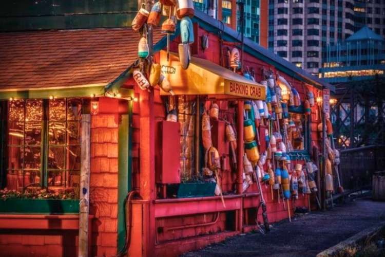 Nighttime scene of Barking Crab Boston restaurant red shack with buoys hanging
