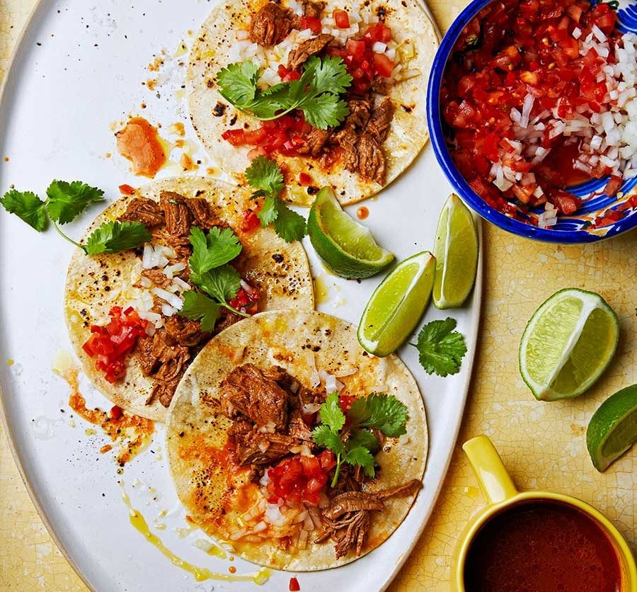Beef birria with lime wedges