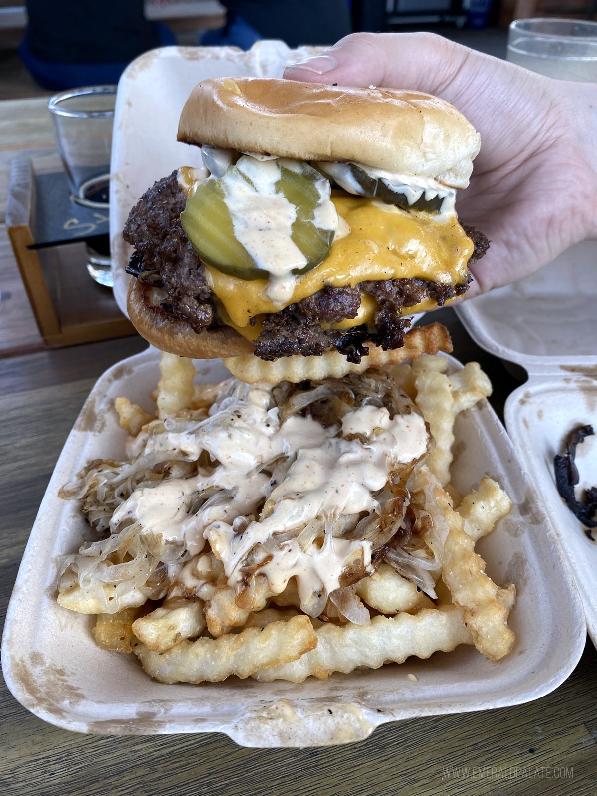 Person Holding a Smash Burger From One of the Best Seattle Food Trucks