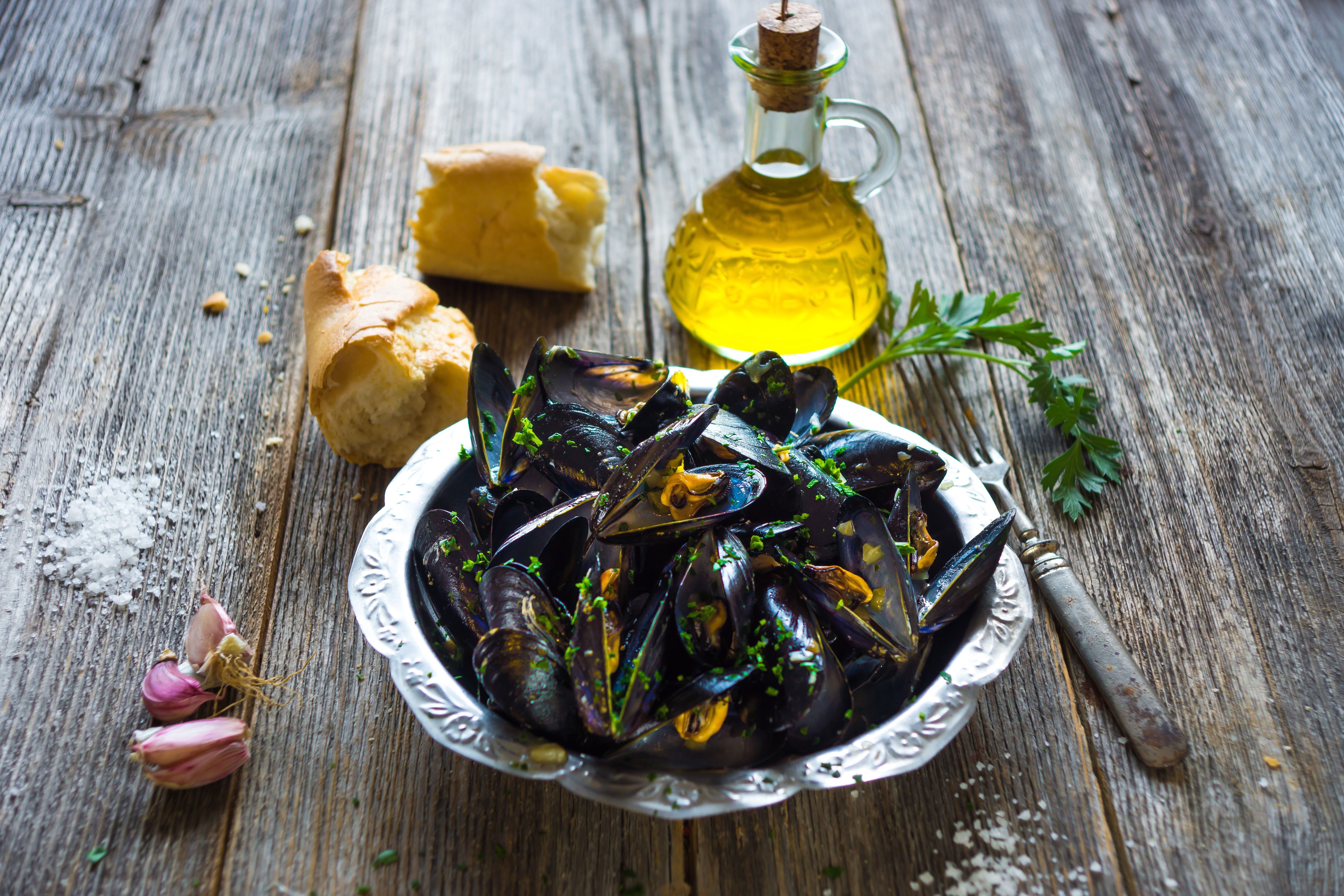Mussels in a bowl topped with herbs