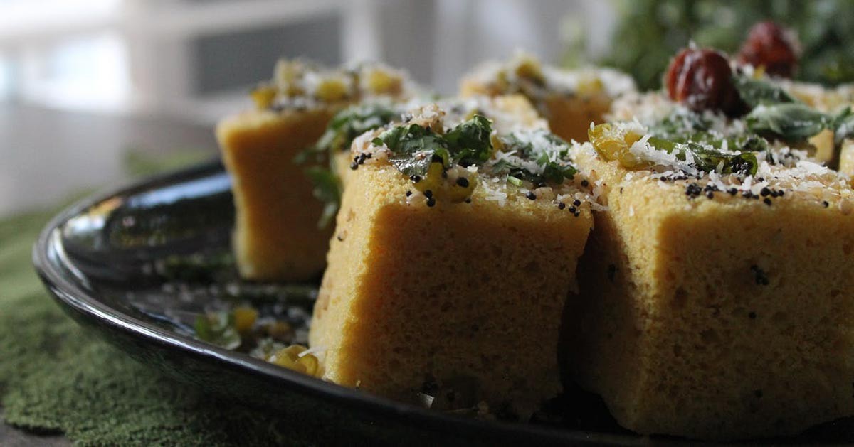 A loaf of fresh cornbread on a wooden cutting board.