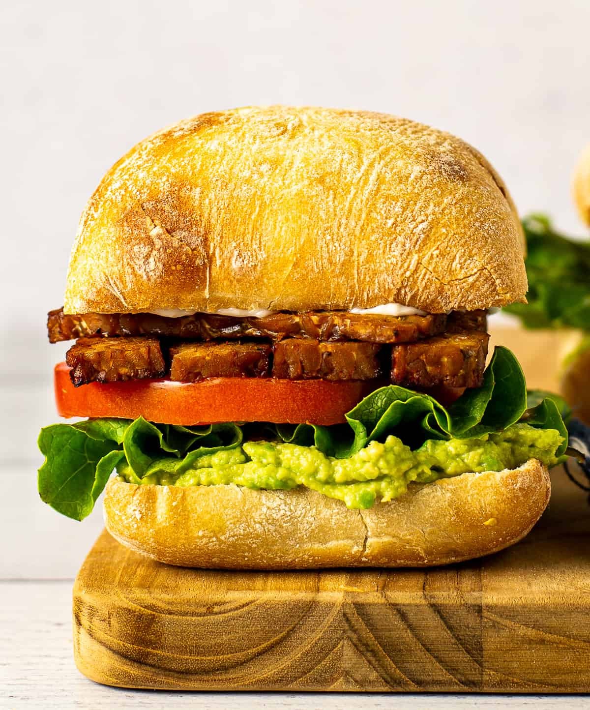 A grilled halloumi and veggie sandwich with roasted vegetables, spinach, and a balsamic glaze.