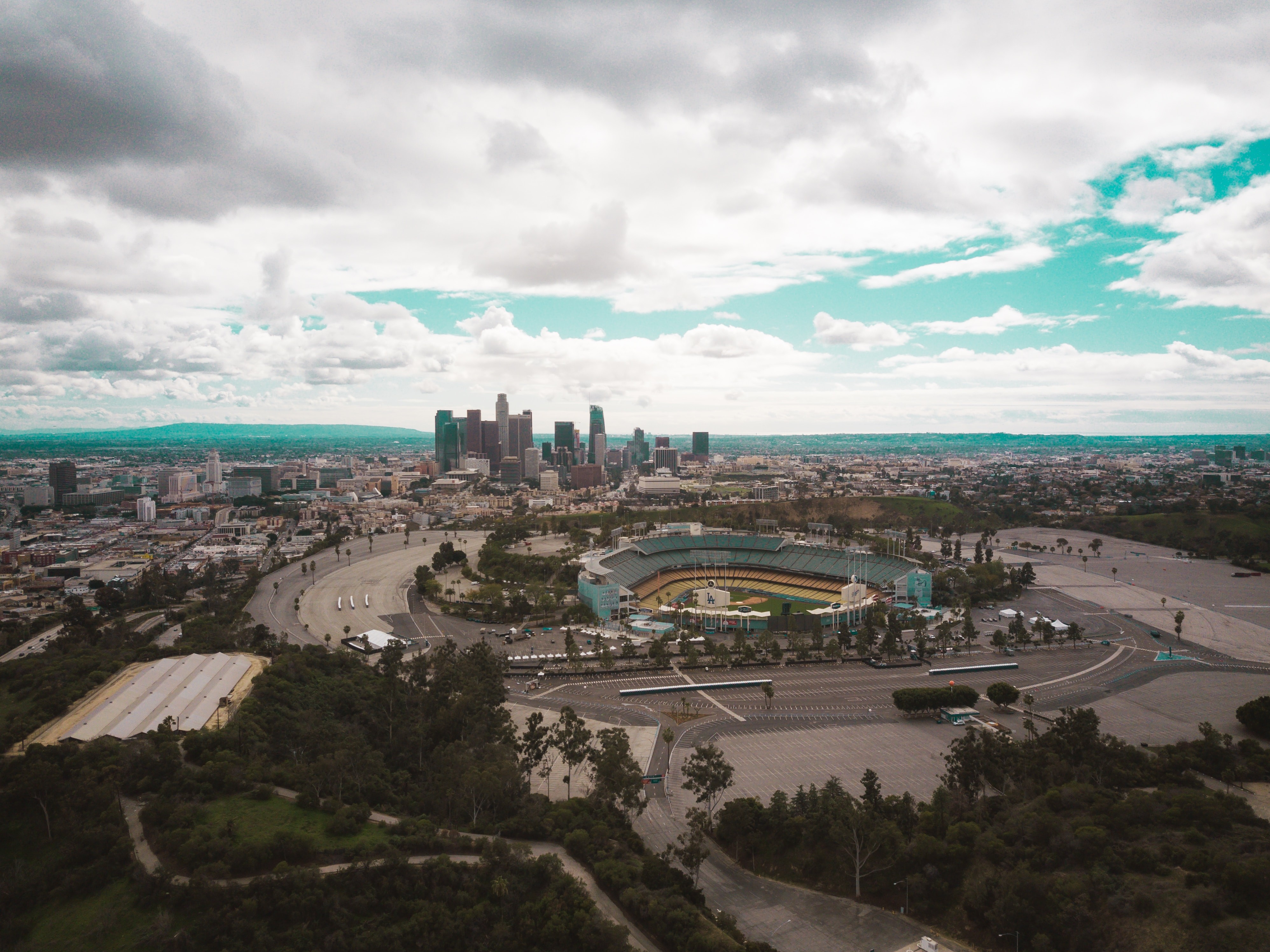 A view of Dodger Stadium off in the distance, with the Los Angeles skyline further away. A view of Dodger Stadium with the Los Angeles skyline in the background, highlighting its accessibility and proximity to downtown attractions