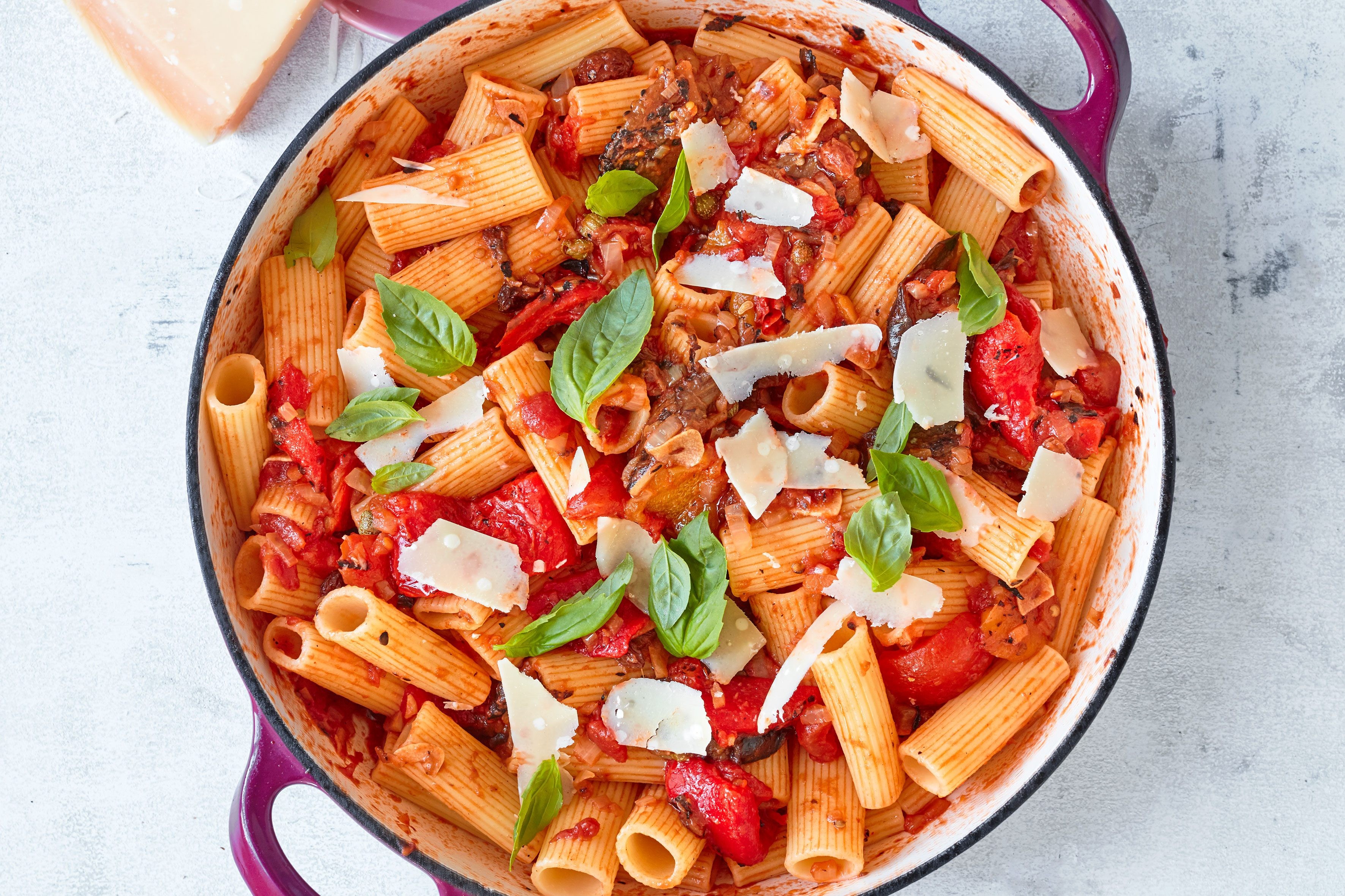 A large pot full of caponata pasta with basil and parmesan