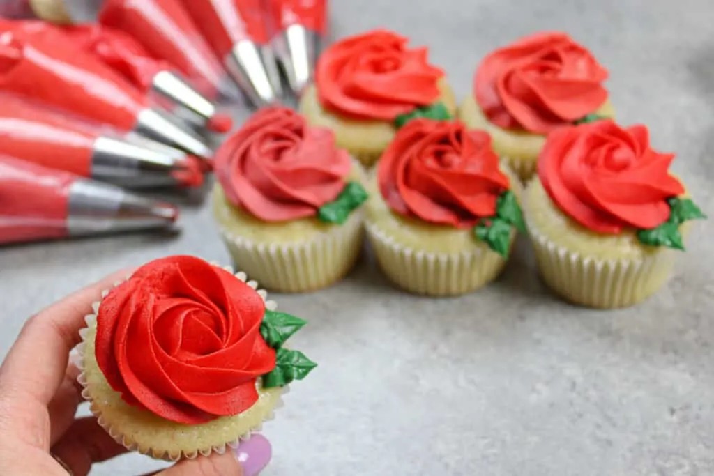Holding a red buttercream rosette cupcake