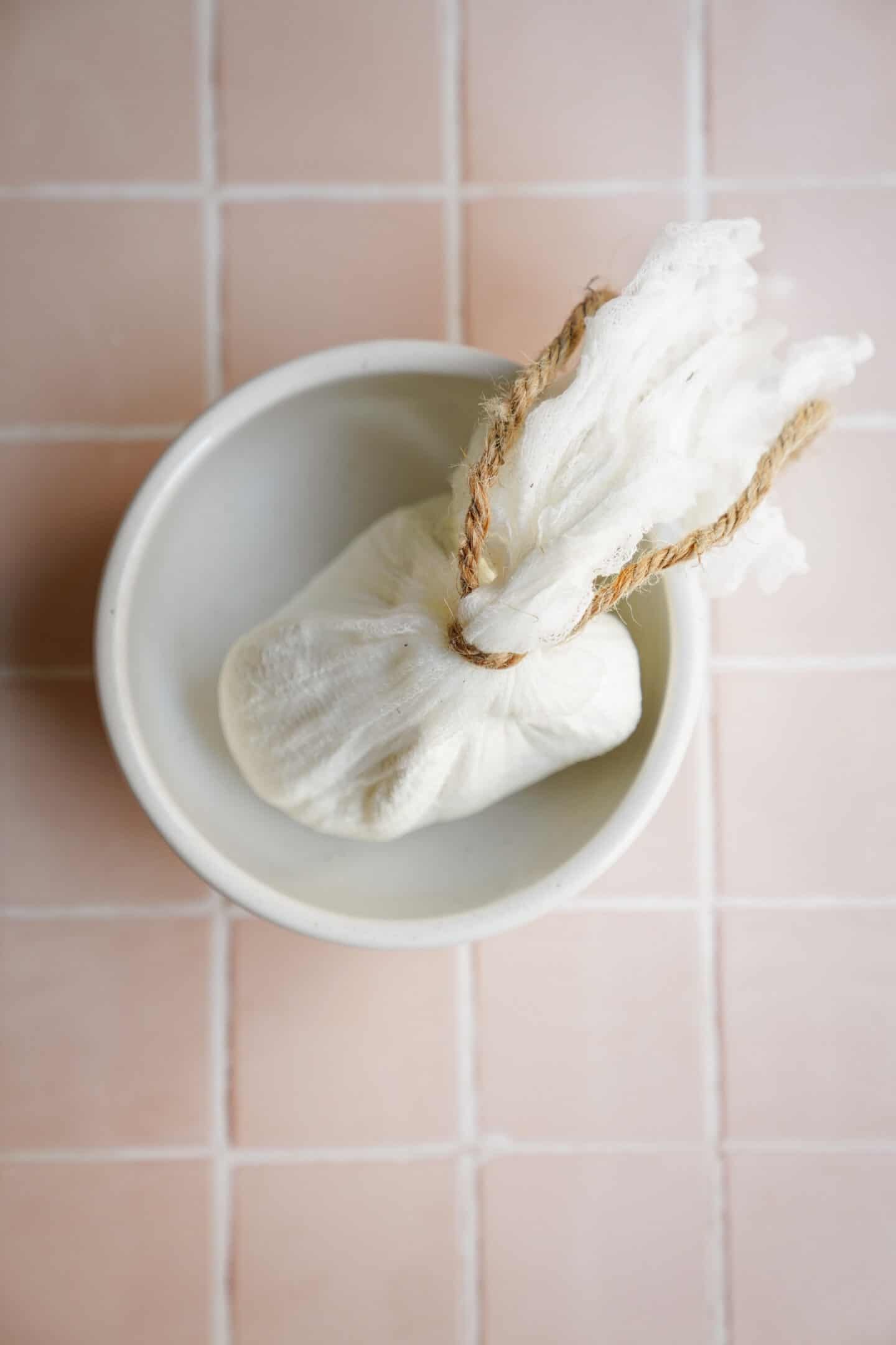 Straining yogurt in cheesecloth to make labneh