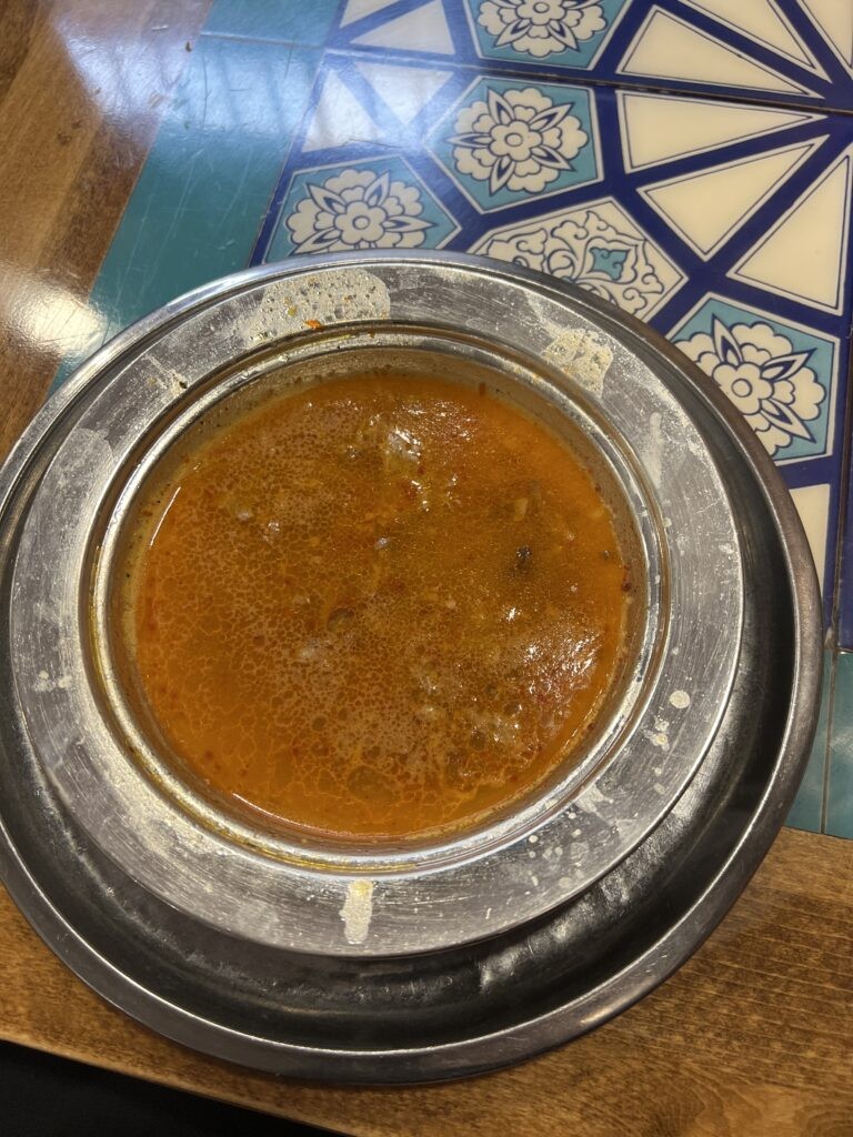 Beyran Çorbası, a traditional Turkish soup made from rendered lamb fat, rice, and shredded lamb meat, served with lemon and bread