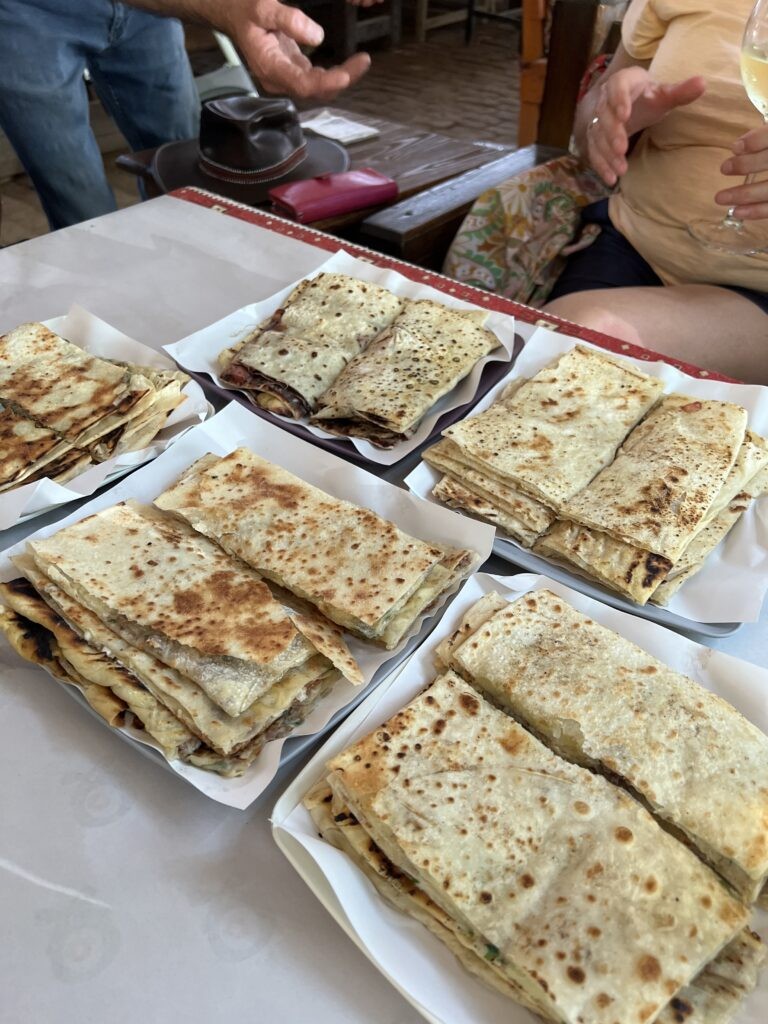 A close-up of Gözleme, a Turkish-stuffed turnover filled with cheese and spinach, cooked on a griddle