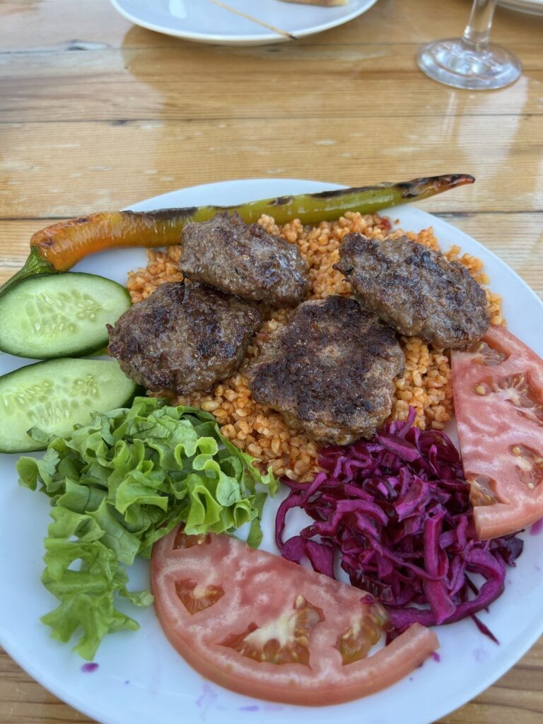 A plate of Köfte, Turkish meatballs made with minced lamb and/or beef, served with vegetables, salad, and rice