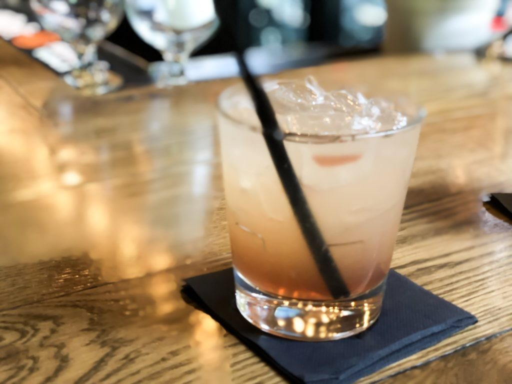 Close-up of a colorful cocktail with a cherry garnish at Carson's Food and Drink