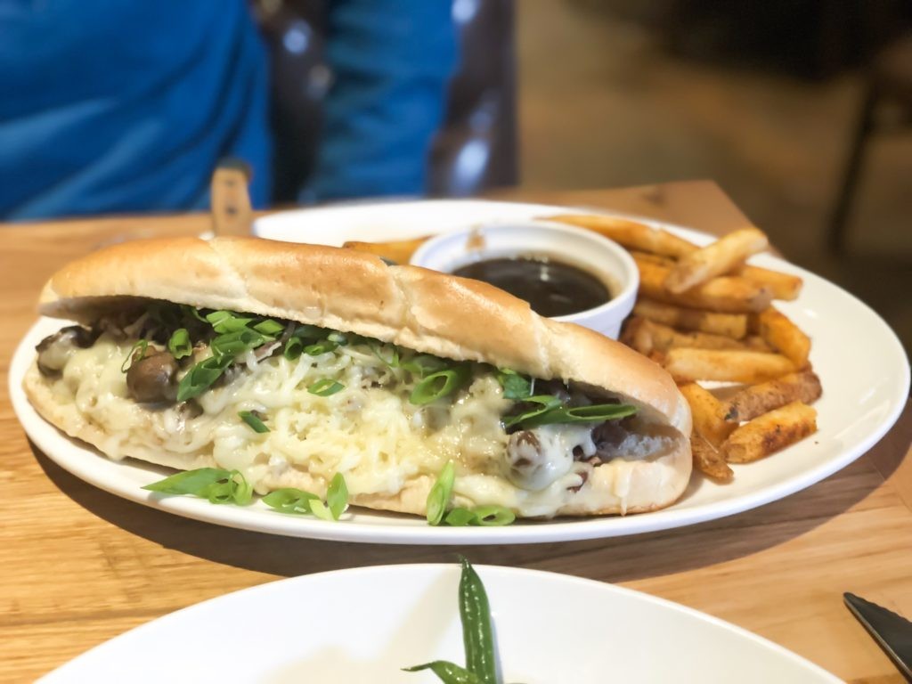 A table setting with a shaved prime rib sandwich at Carson's Food and Drink