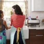 Mother and daughter in the kitchen washing dishes