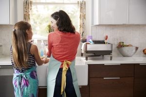 Mother and daughter in the kitchen washing dishes