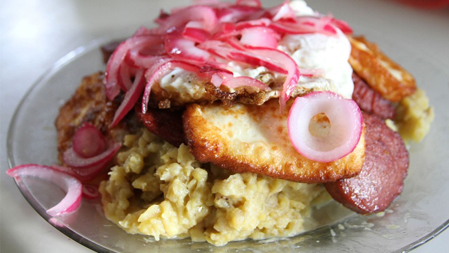 Dominican Mangu dish with mashed plantains, onions, and cheese. Alt text: Mangú, a traditional Dominican breakfast, featuring mashed plantains topped with sautéed red onions.