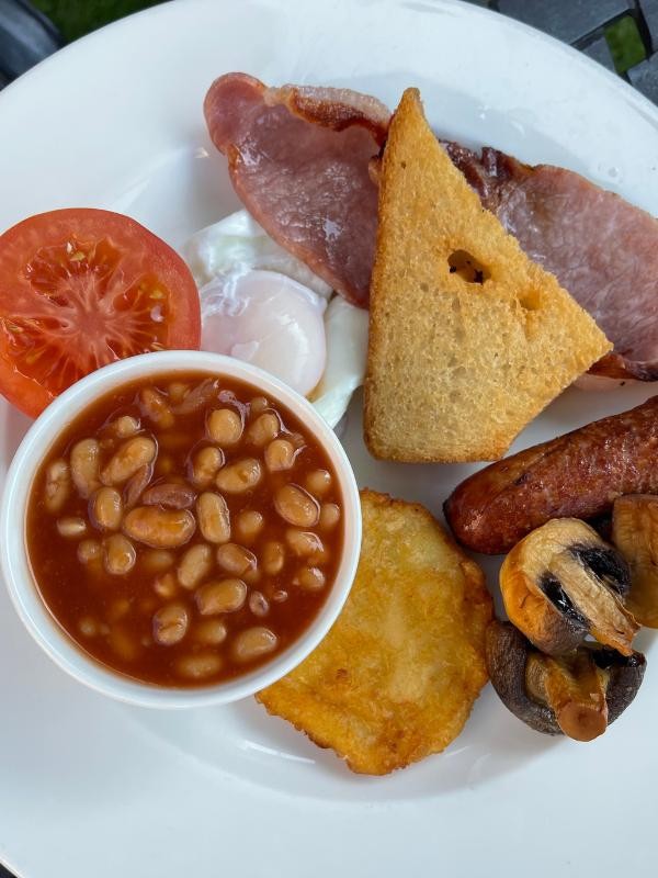 Full English Breakfast featuring sausages, eggs, bacon, and toast, a hearty London classic.