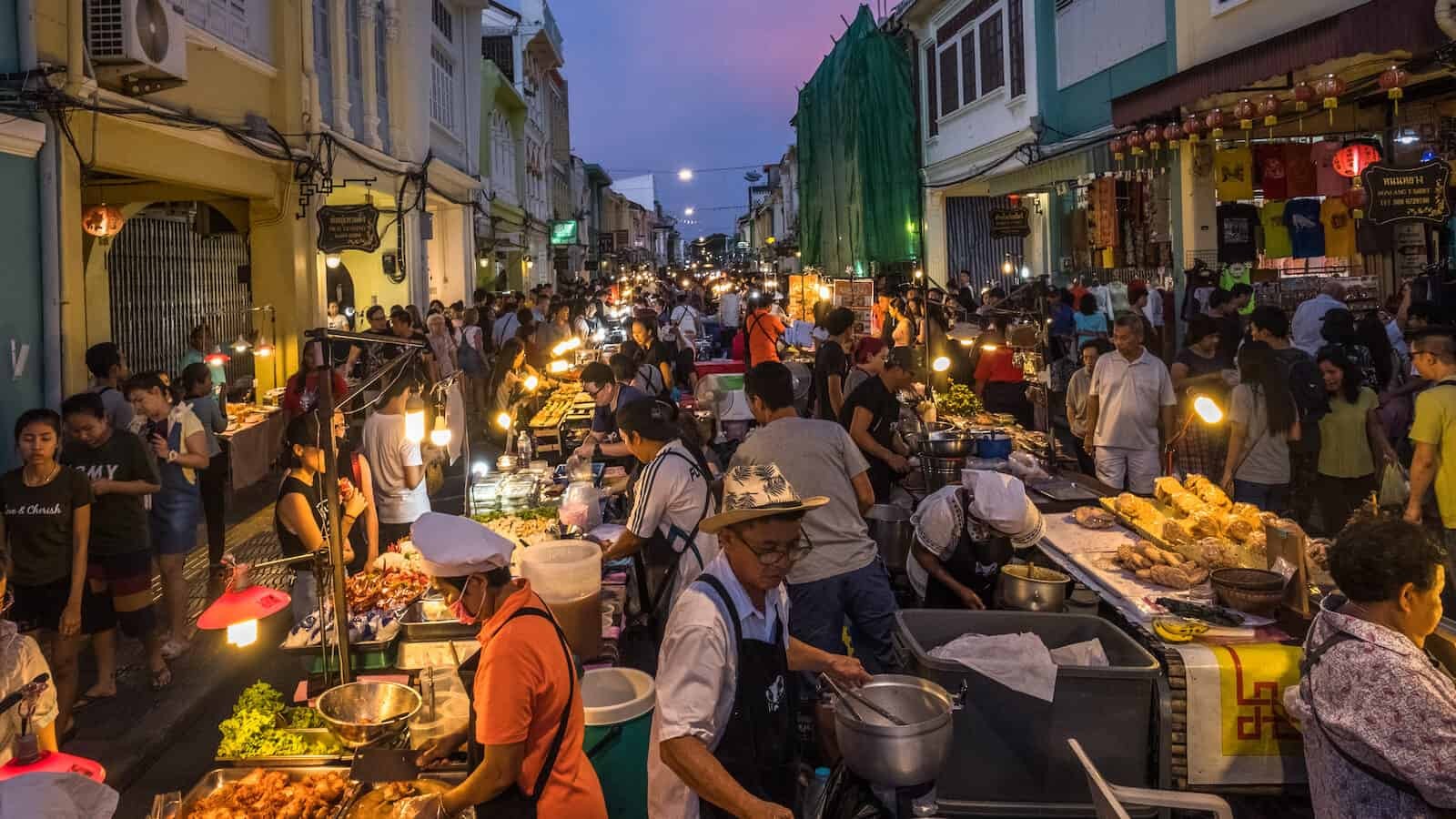 A vibrant street scene in Phuket Town, Thailand, showcasing the bustling food stalls and the colorful array of Thai dishes, reflecting the country's rich culinary heritage